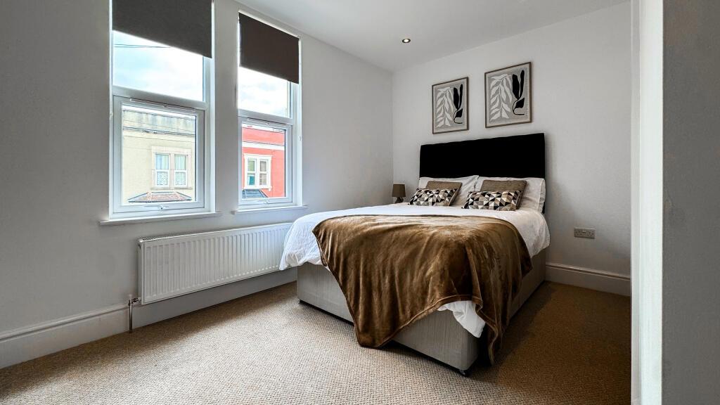 This inviting double bedroom features a comfort...