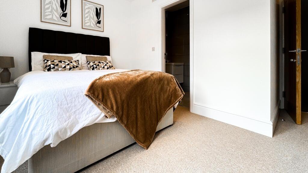 This inviting double bedroom features a cozy at...