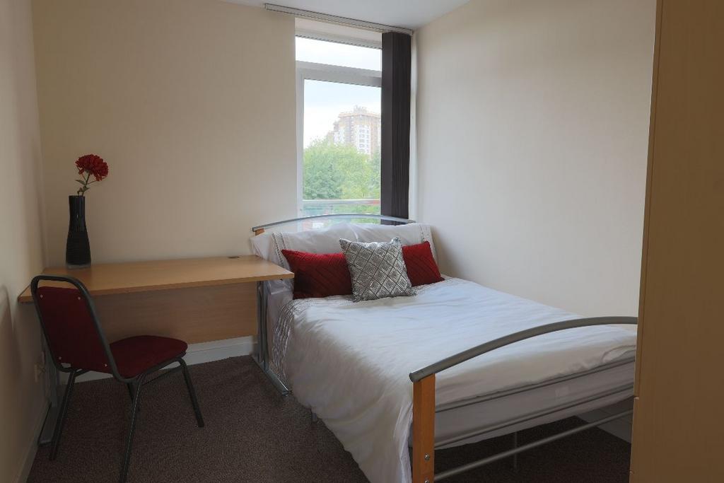 A cozy, well-kept single bedroom featuring a ne...