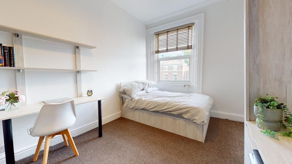 A bright and tidy double bedroom featuring a co...