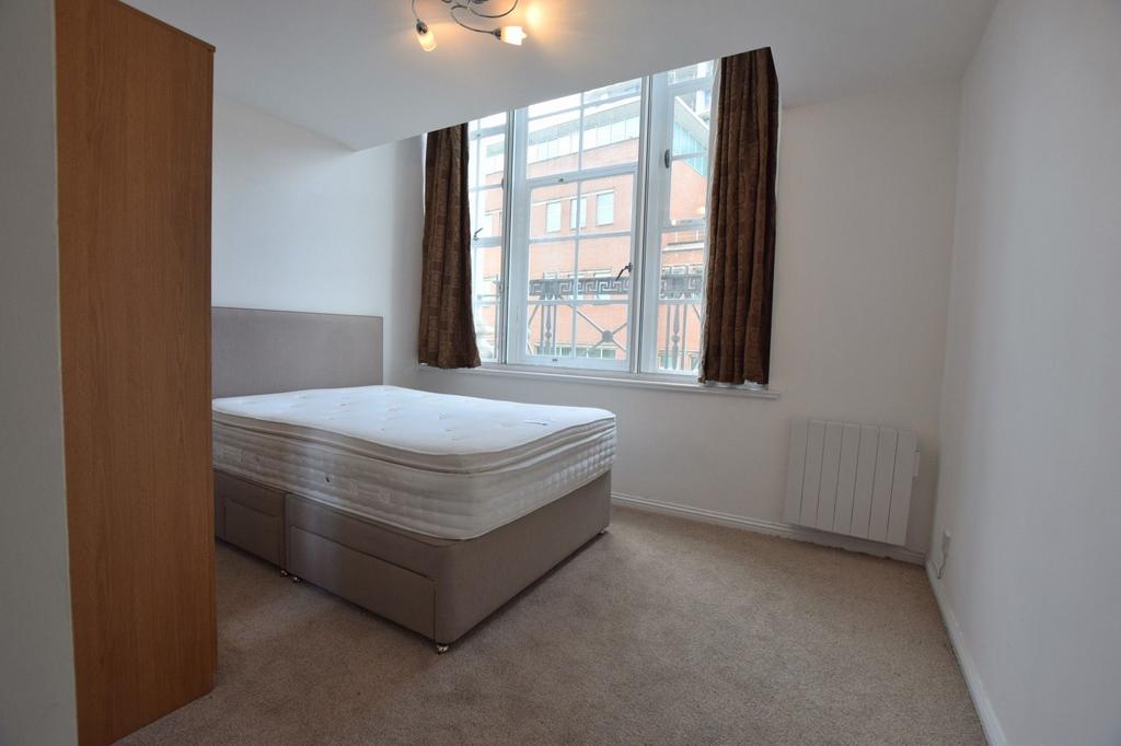 Bright double bedroom featuring a large window ...