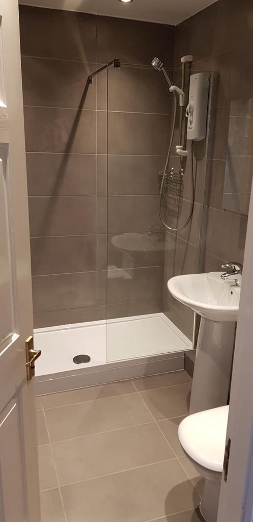A modern bathroom featuring a spacious walk-in ...