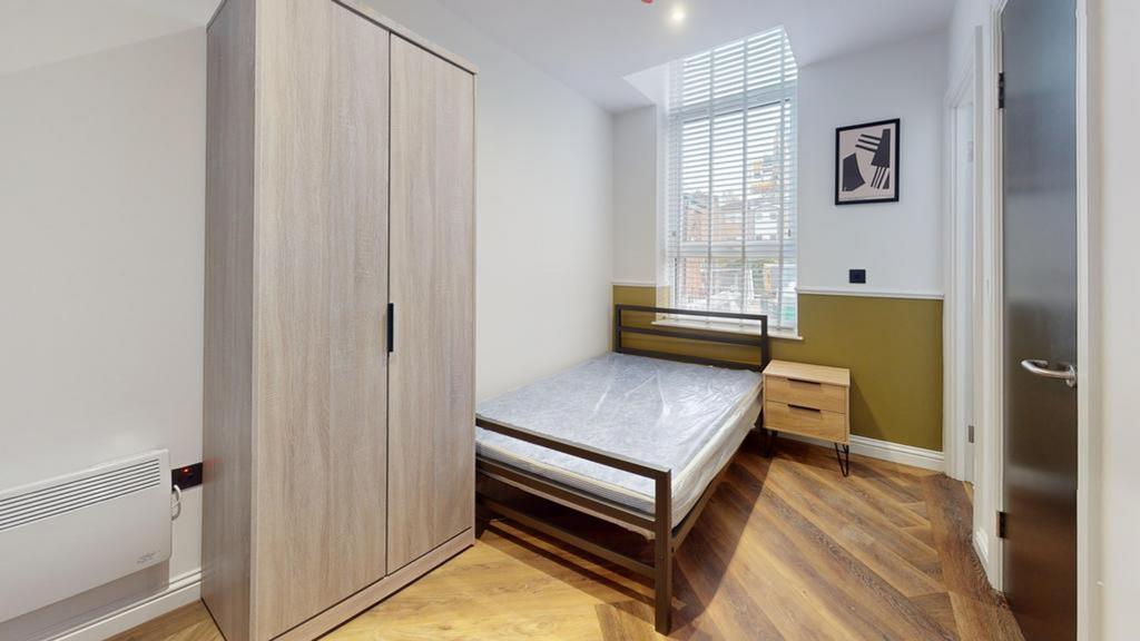 A bright and modern double bedroom featuring st...