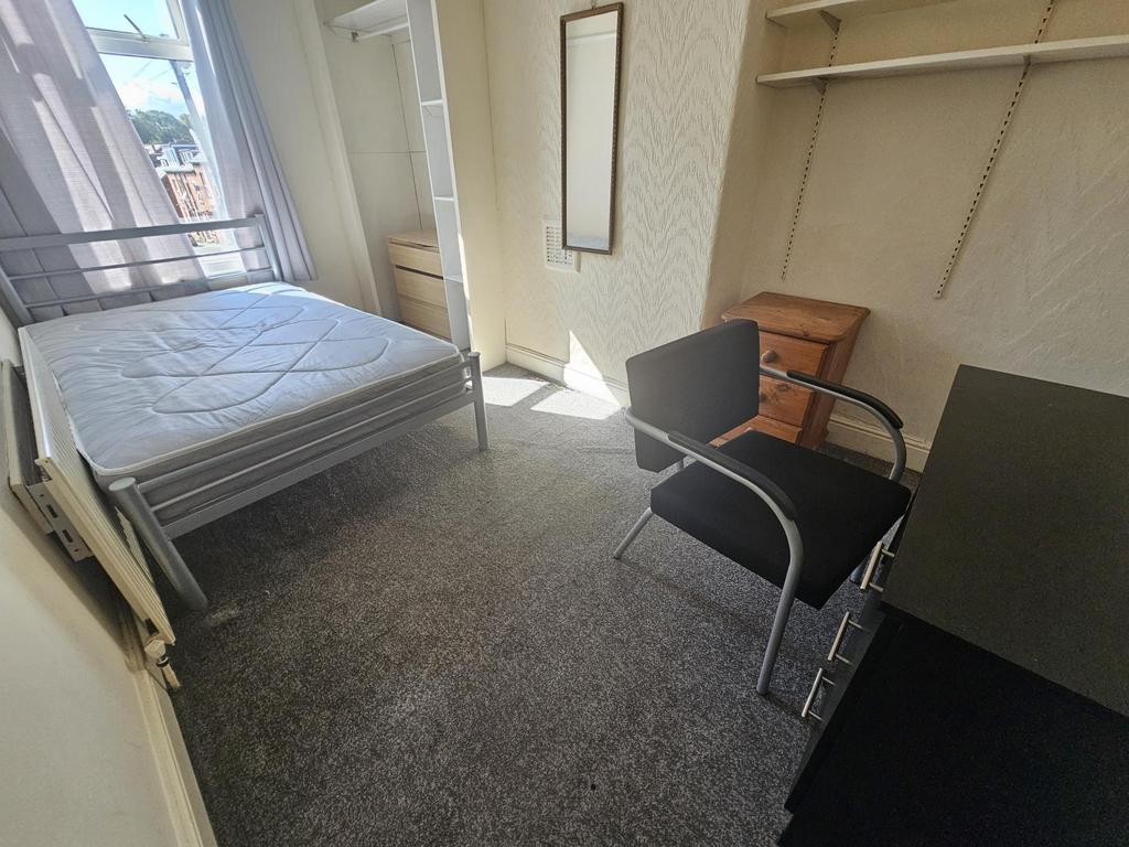 A well-lit bedroom featuring a double bed and a...