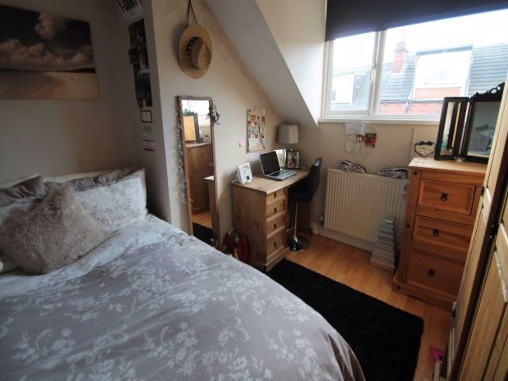 A cozy single bedroom featuring a comfortable b...