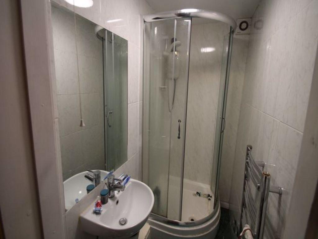 A clean, modern bathroom featuring a corner sho...