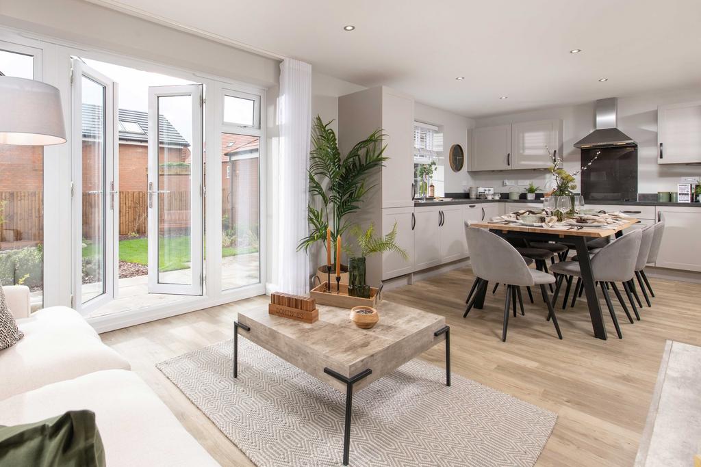 Open-plan kitchen with French doors in the four...
