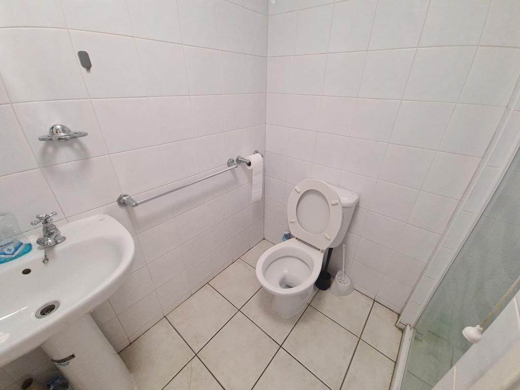 A clean and simple single toilet room featuring...