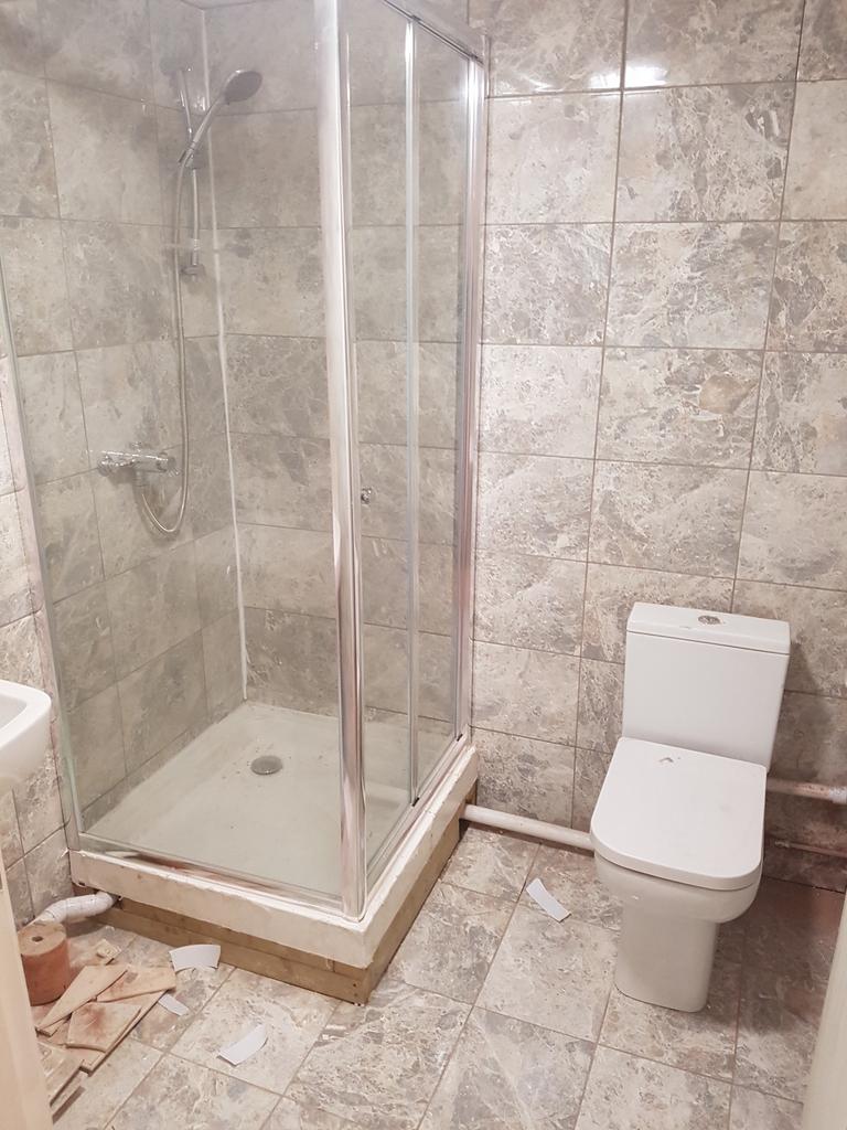 A functional bathroom featuring a modern shower...