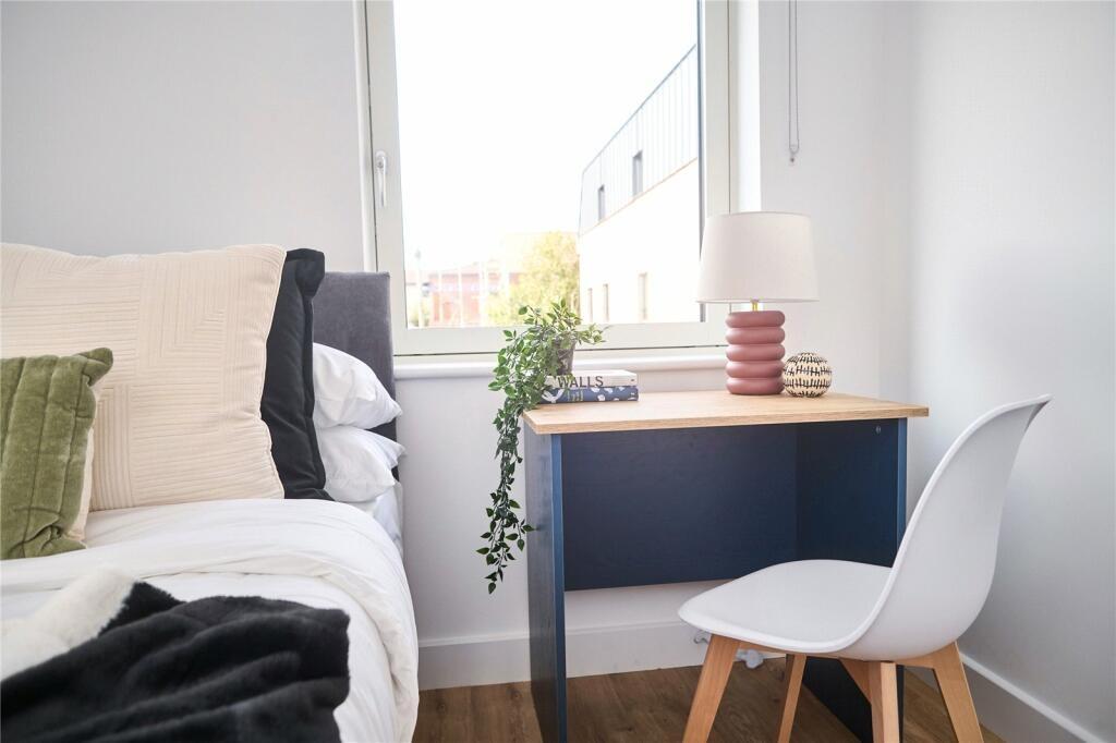A bright and tidy single bedroom featuring a co...