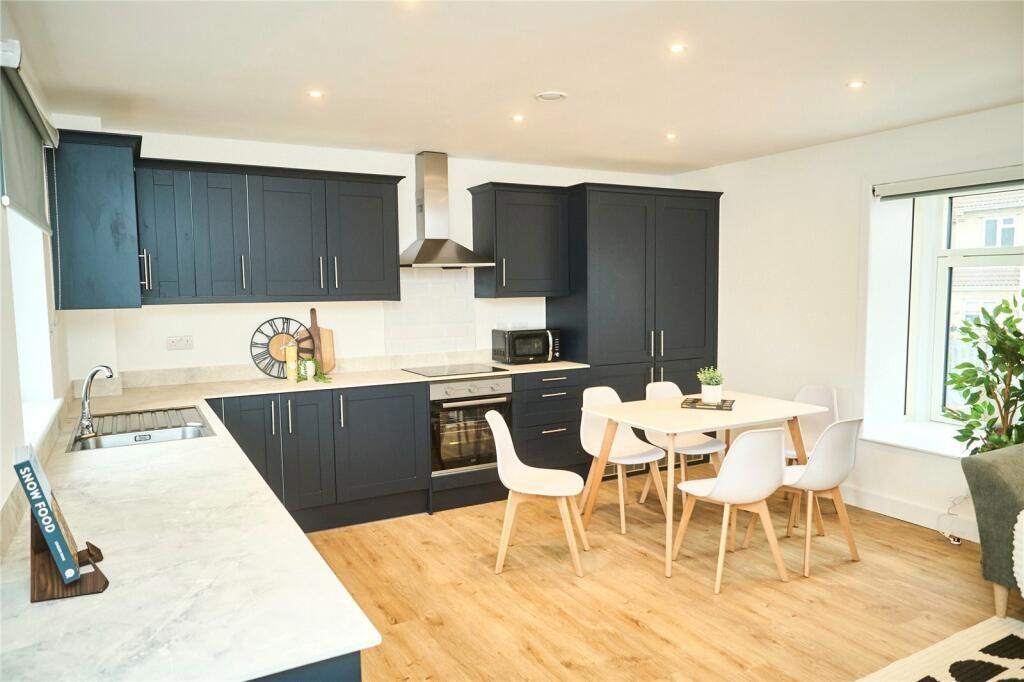 A modern kitchen featuring sleek black cabinetr...