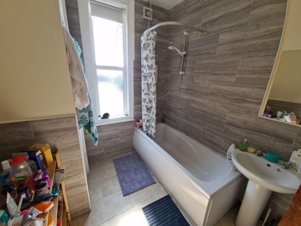 Bright bathroom suite featuring a modern bathtu...