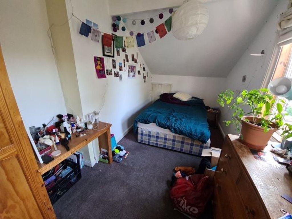 A cozy single bedroom featuring a comfortable b...