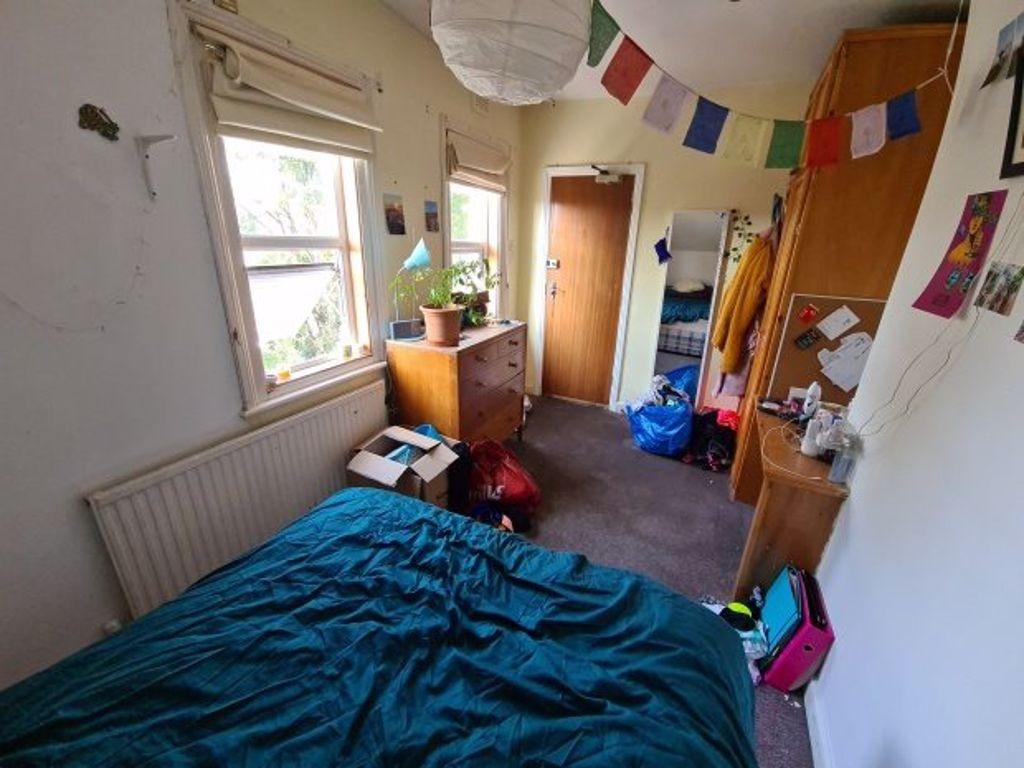 Cozy and well-lit small bedroom featuring a com...
