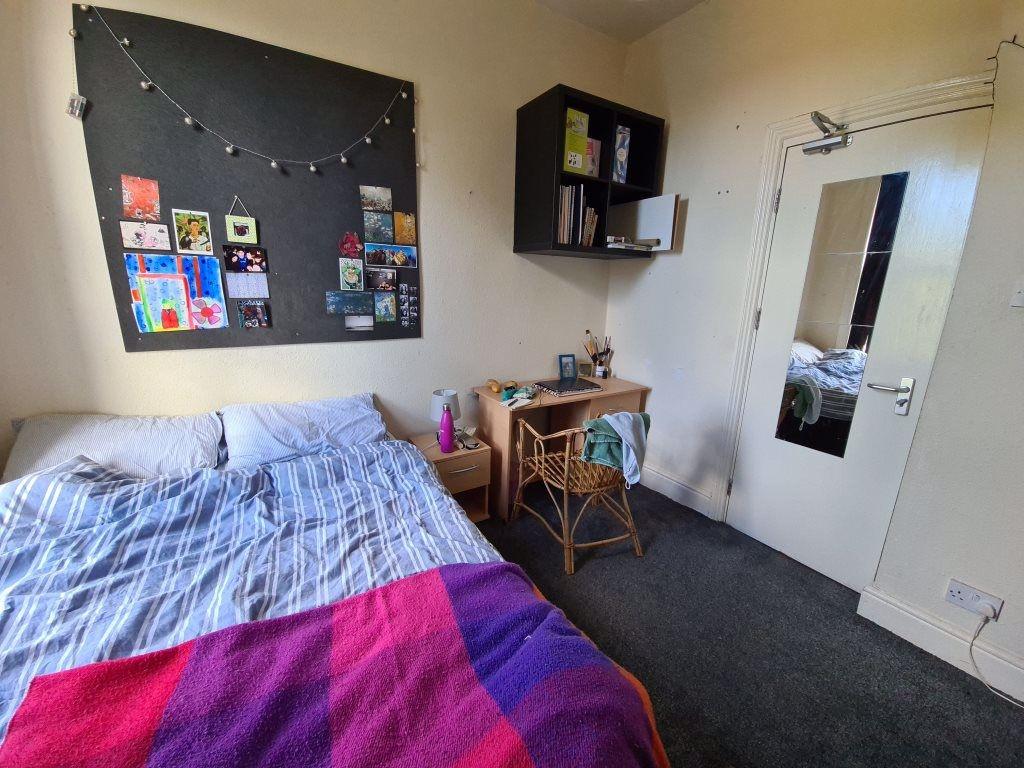 A cozy bedroom featuring a bed with a colorful ...