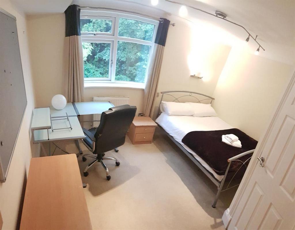 A tidy and well-lit single bedroom featuring a ...
