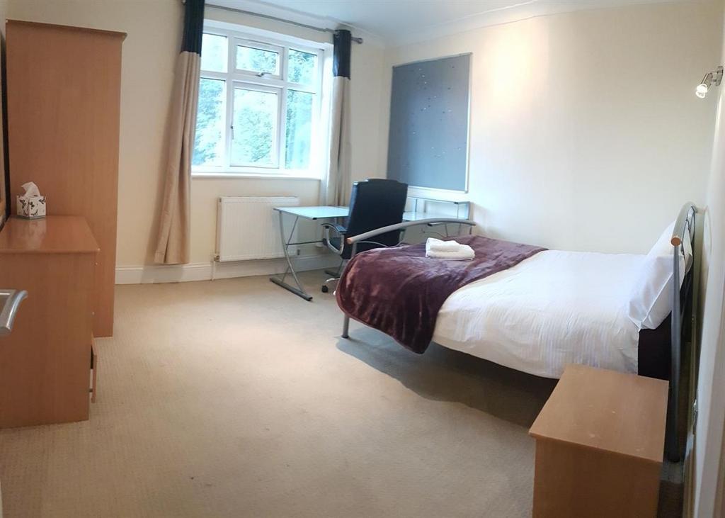 A tidy student bedroom featuring a single bed, ...
