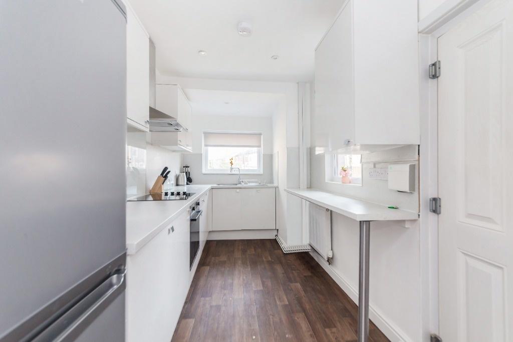 Bright and modern kitchen featuring white cabin...