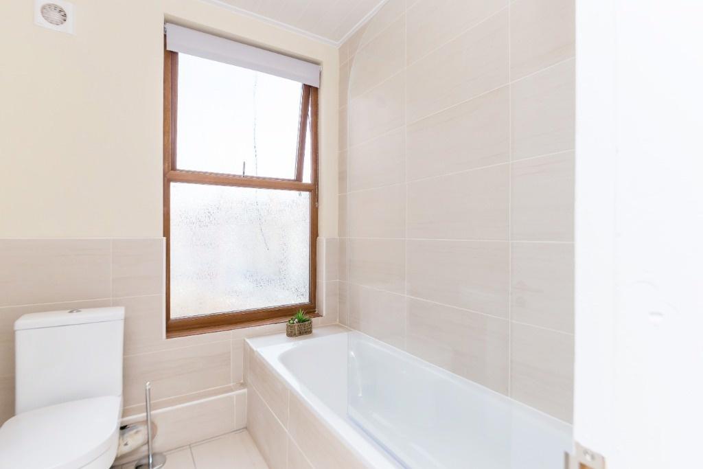 Bright and clean bathroom suite featuring a spa...