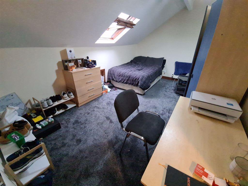 A cozy attic bedroom featuring a single bed und...