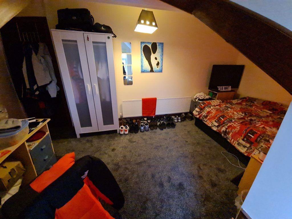 Cozy single bedroom in an attic space featuring...