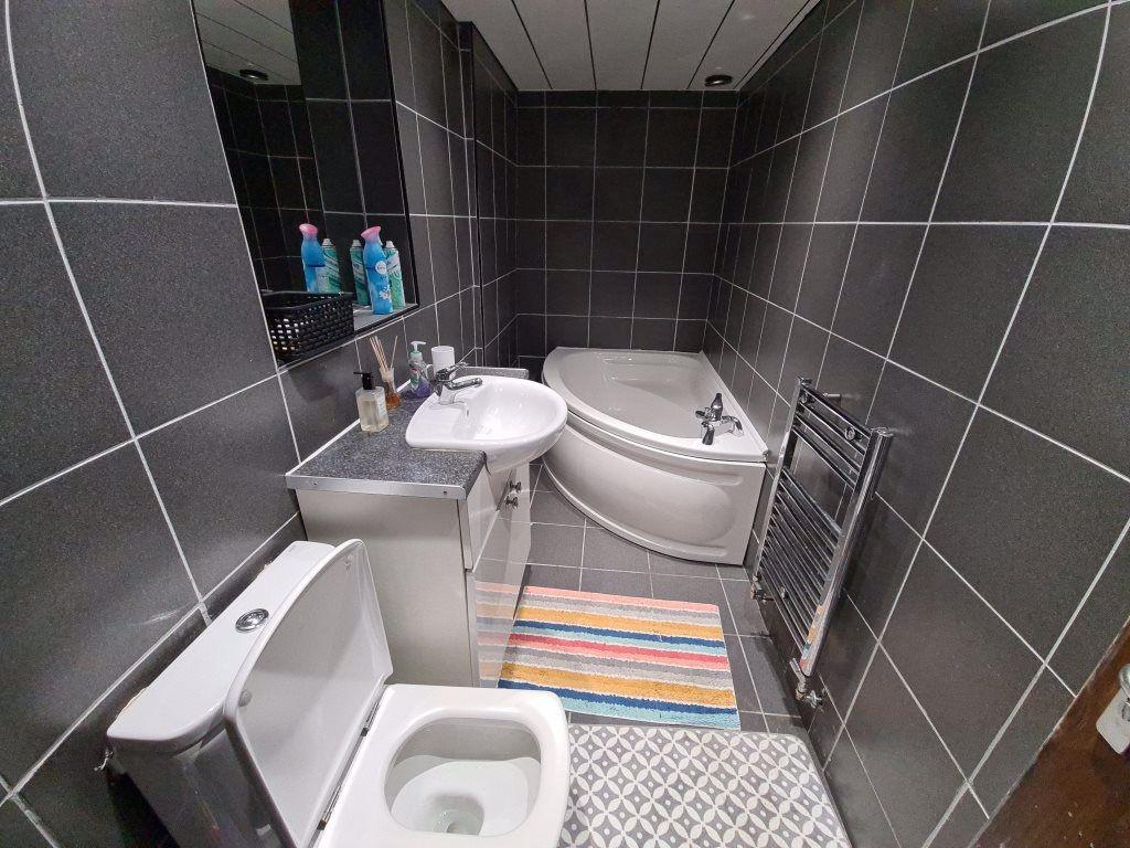 Modern bathroom suite featuring a corner bathtu...
