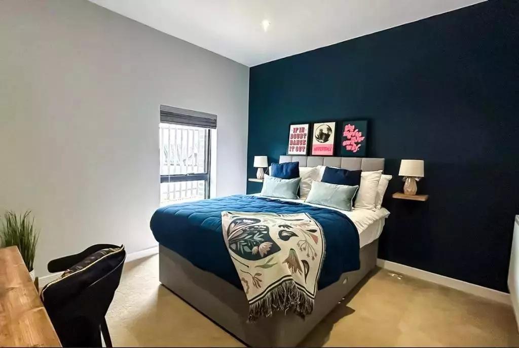 A stylish master bedroom featuring a comfortabl...