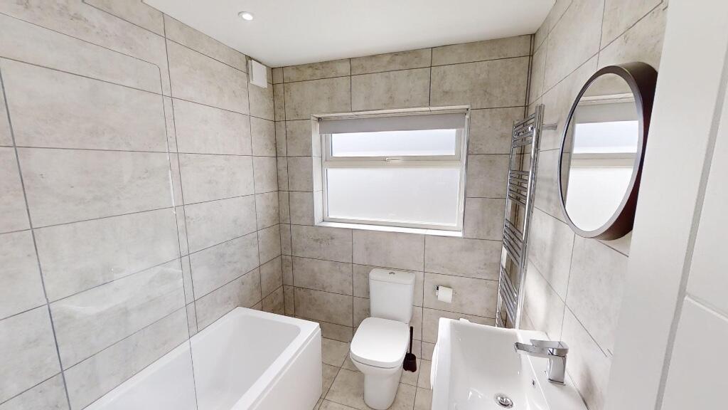Bright and modern bathroom featuring a full-siz...
