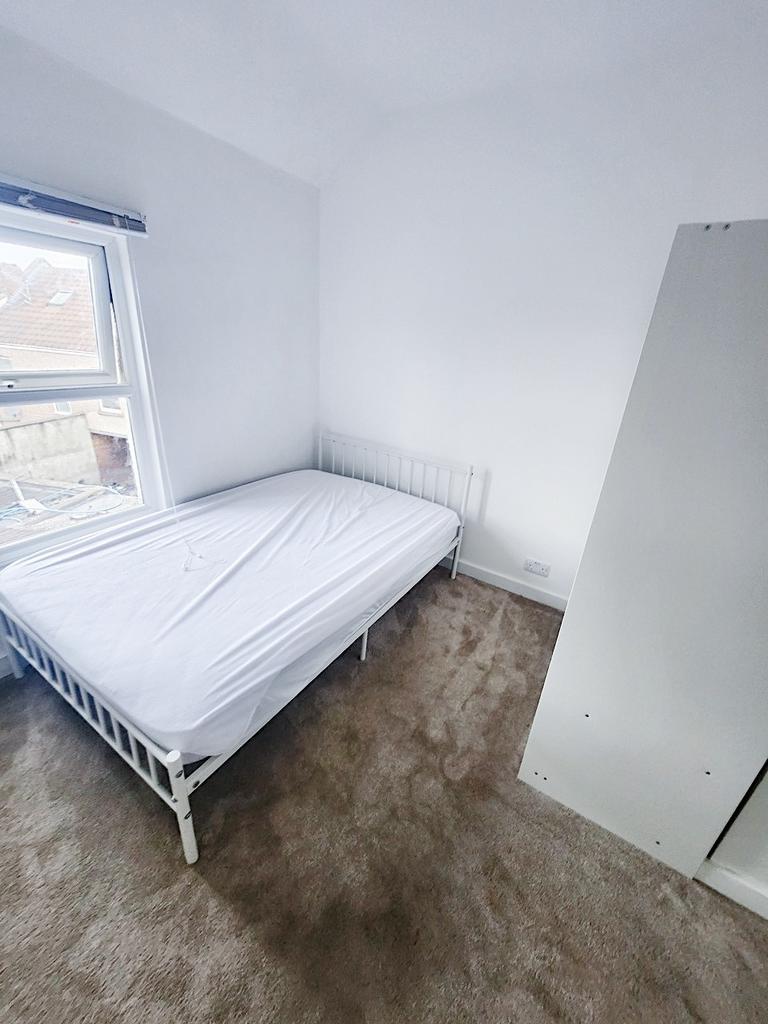 Bright, freshly painted bedroom with a white me...
