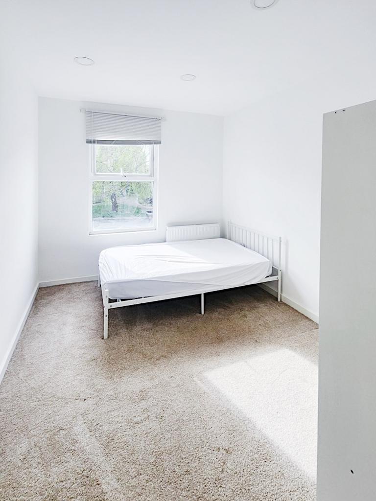 Bright, minimalist bedroom with a large window,...