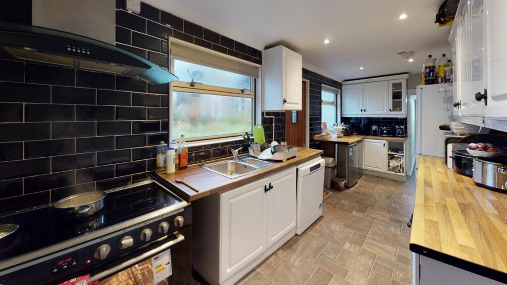 This modern kitchen features sleek cabinetry, a...