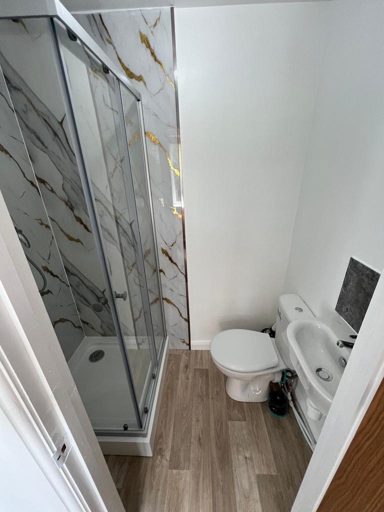 A clean, modern bathroom featuring a glass-encl...