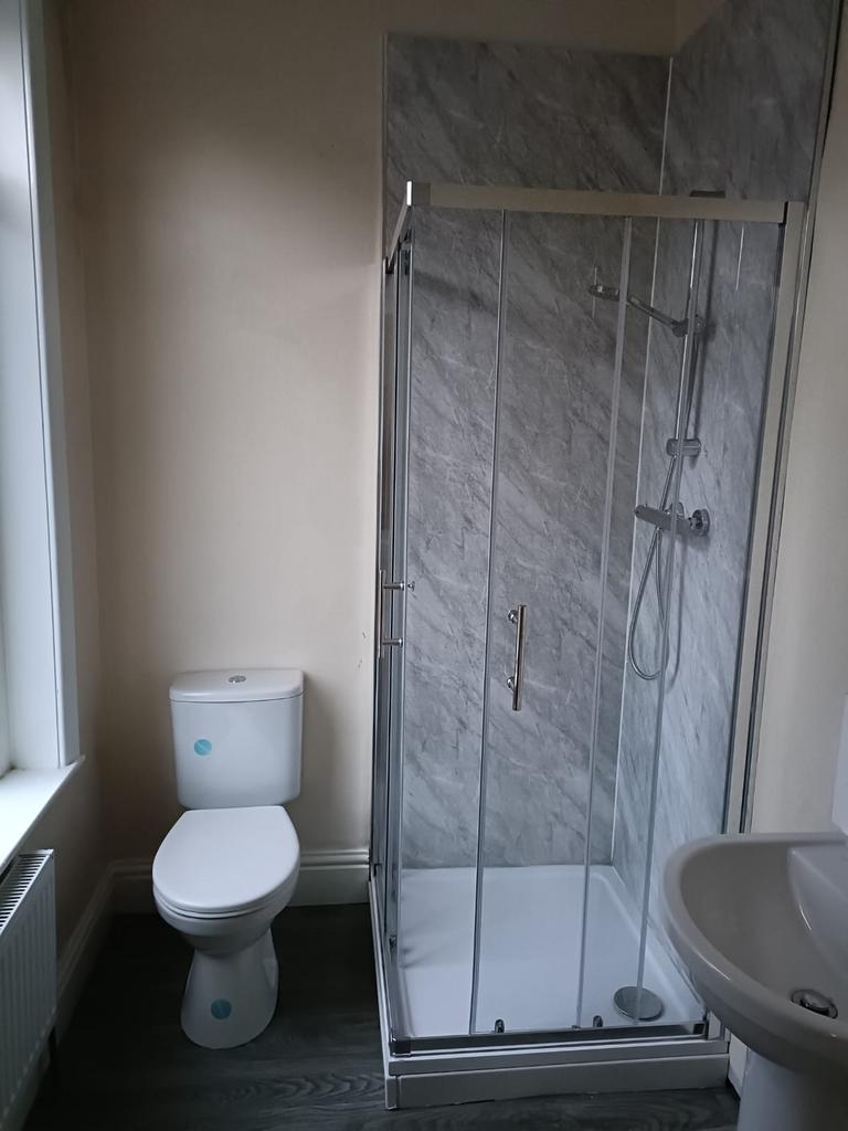 A clean and modern bathroom featuring a glass-e...