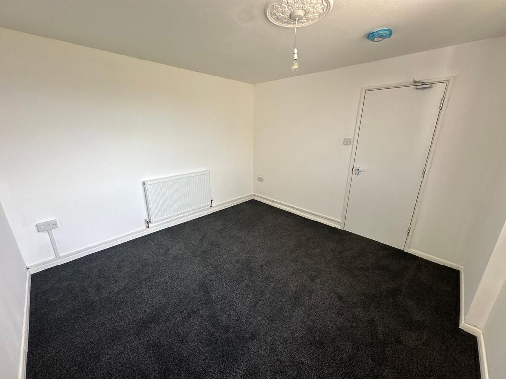 A freshly painted single bedroom with clean whi...