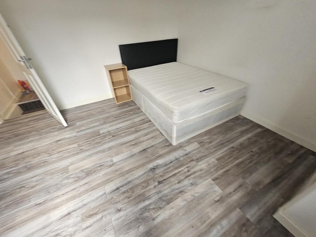 A spacious master bedroom featuring a large bed...