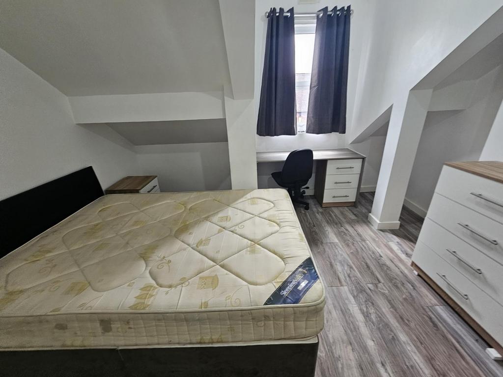 A bright and tidy bedroom featuring a double be...