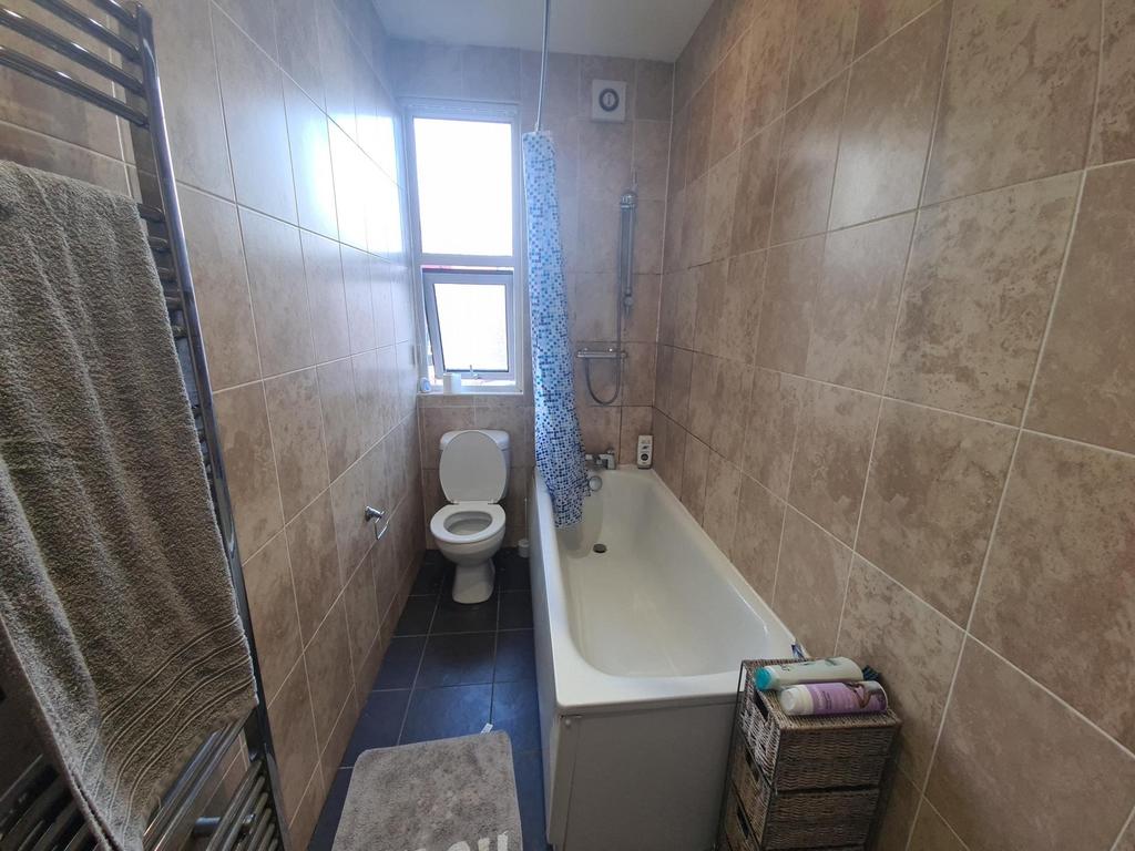 A clean bathroom featuring a bathtub, a toilet,...