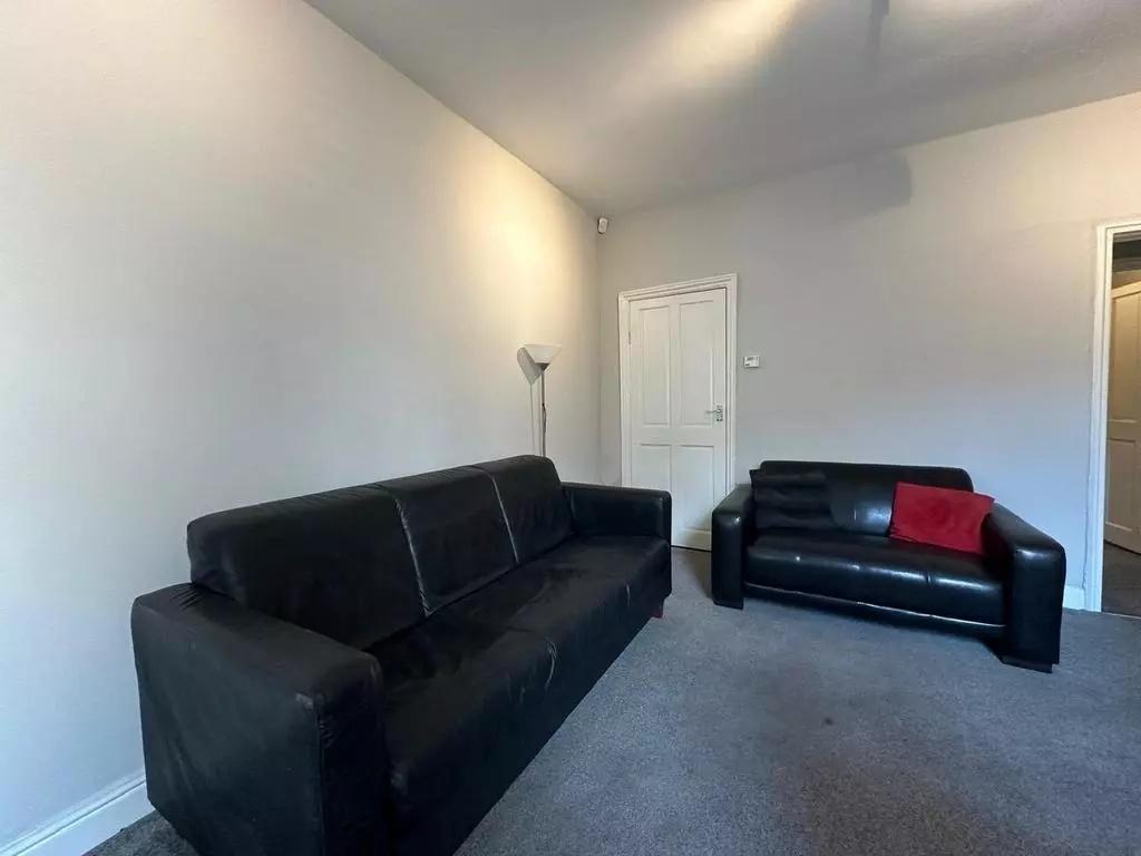 A cozy living room featuring two black sofas on...