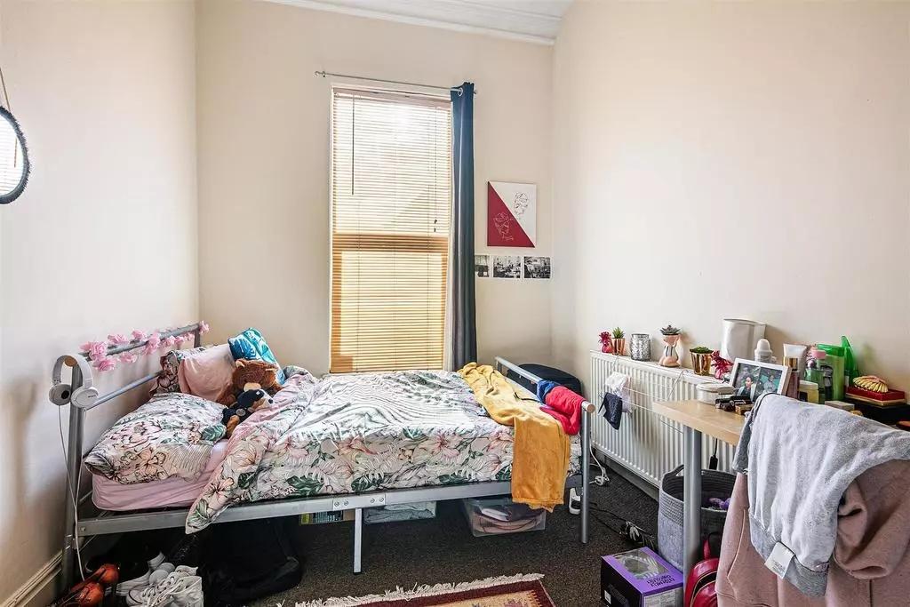 Cozy single bedroom featuring a comfortable bed...