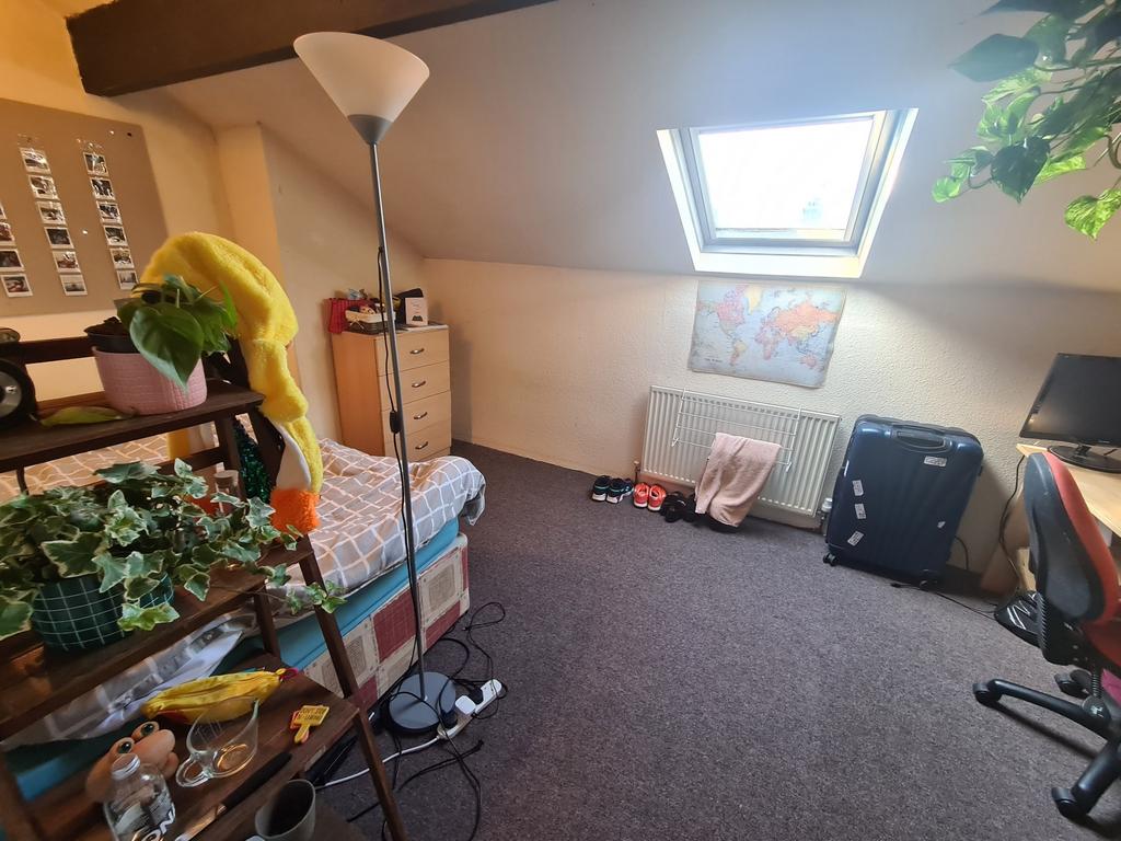 A cozy attic bedroom featuring a skylight that ...