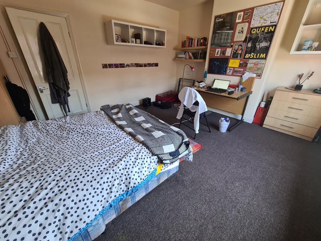 A cozy double bedroom featuring a neatly made b...