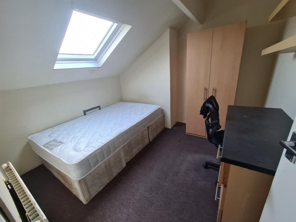 A cozy single bedroom featuring a comfortable b...