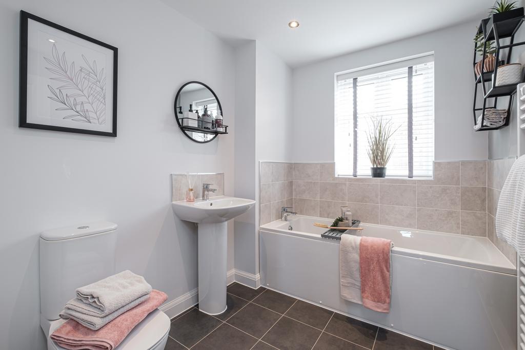 Photo of a modern grey tiled bathroom with bath