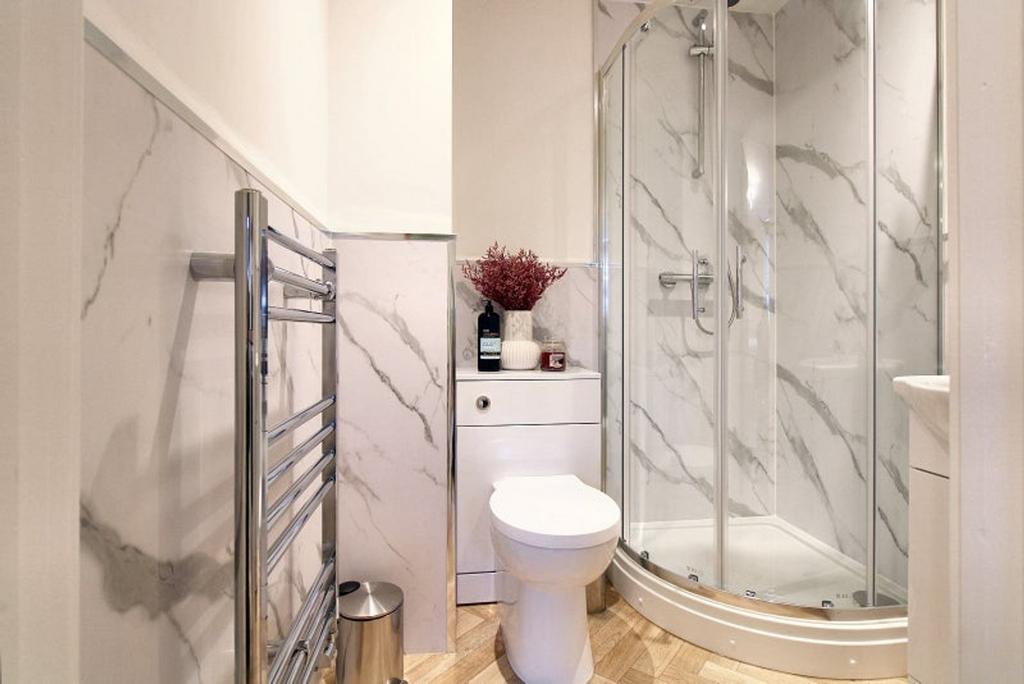 A modern bathroom featuring elegant marble wall...