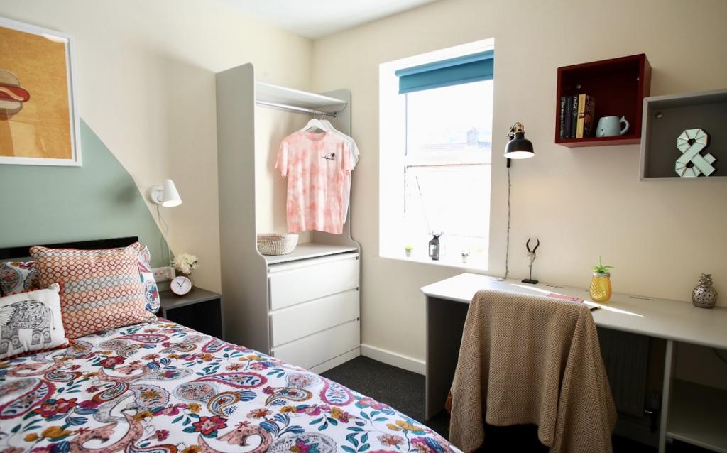 This cozy double bedroom features a vibrant dec...