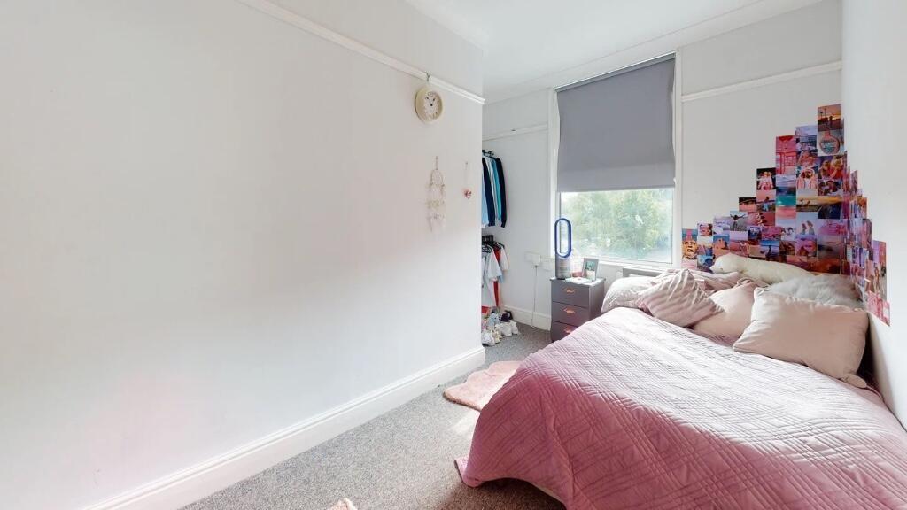 A cozy bedroom featuring a comfortable single b...