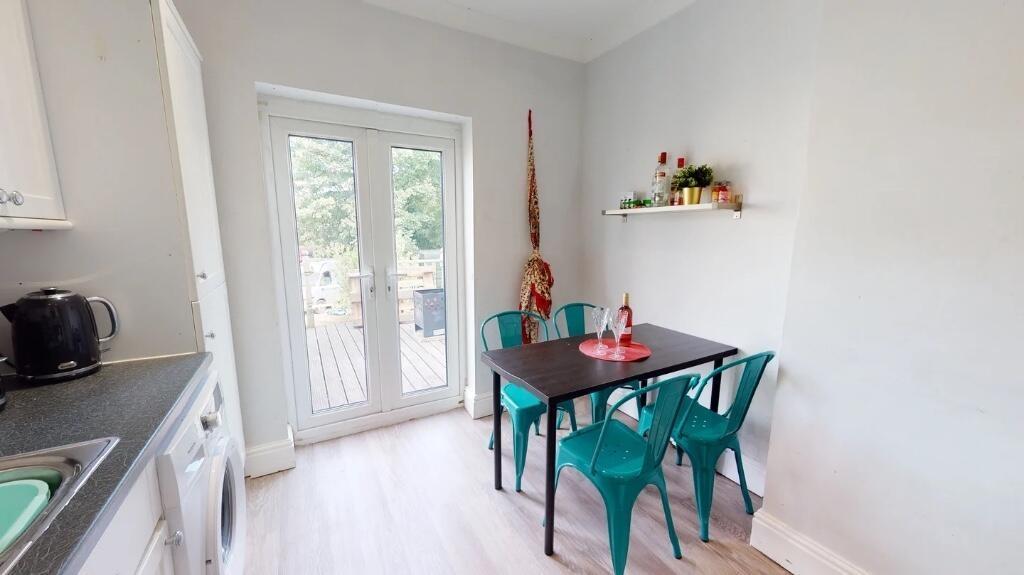 A bright and modern kitchen featuring light woo...