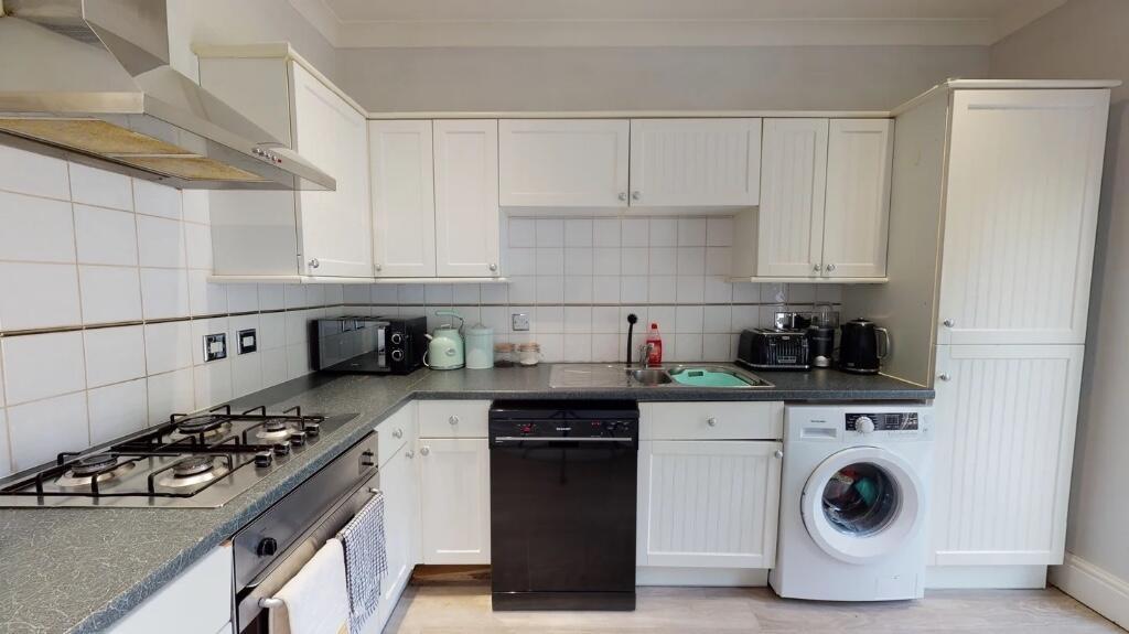 Bright and tidy kitchen featuring modern white ...