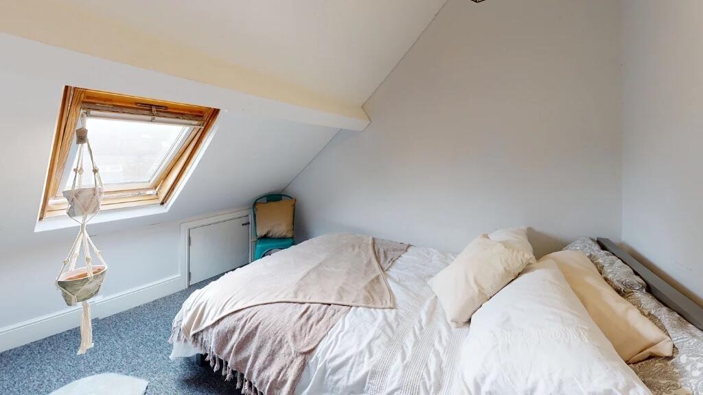 A cozy and well-lit master bedroom featuring a ...