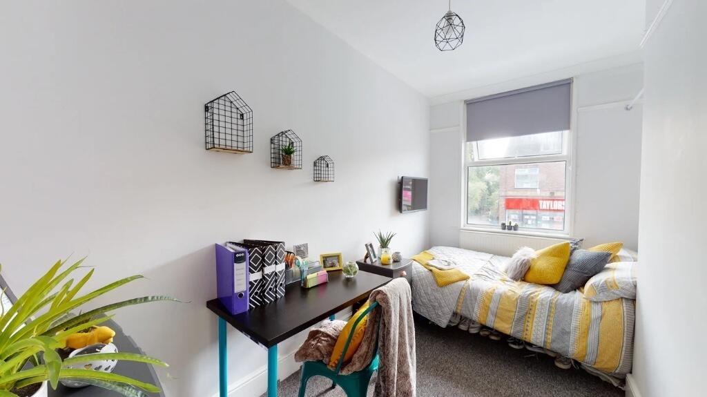 A bright and cozy single bedroom featuring a co...
